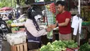 Pedagang melayani pembeli di pasar kawasan Tangerang, Senin (7/2/2022). Ekonom Centre for Strategic and International Studies (CSIS) meminta pemerintah bisa mengantisipasi ketersediaan bahan pokok seiring peningkatan kasus COVID-19 varian Omicron. (Liputan6.com/Angga Yuniar)