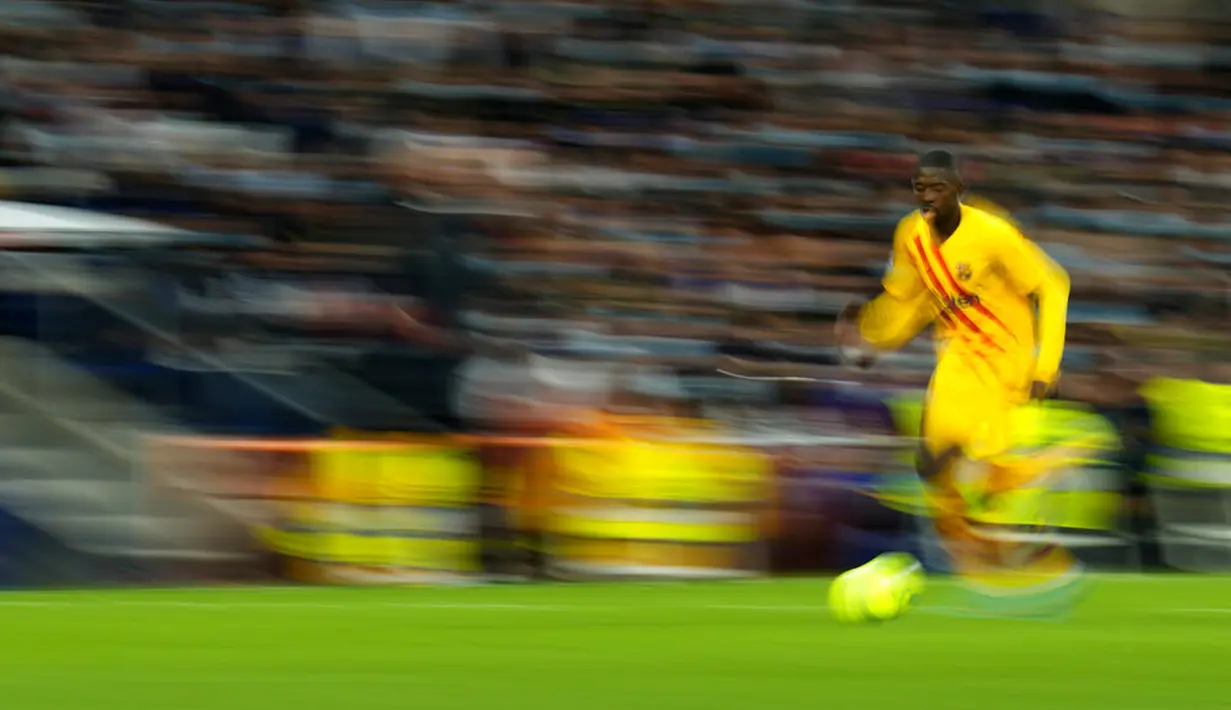 Dalam foto yang diambil dengan kecepatan rana lambat ini, pemain Barcelona Ousmane Dembele menggiring bola saat melawan Real Madrid pada pertandingan sepak bola La Liga Spanyol di Stadion Santiago Bernabeu, Madrid, Spanyol, Minggu (20/3/2022). Barcelona menang 4-0. (AP Photo/Manu Fernandez)