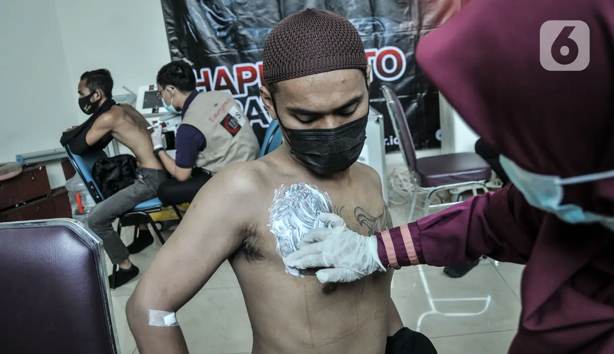 Peserta melalui proses anestesi atau pemberian krim sebelum penghapusan tato di Masjid Baitul Muhyi, Kompleks Wali Kota, Jakarta Timur, Jakarta, Kamis (29/4/2021). 
Layanan hapus tato gratis untuk 550 orang se-DKI Jakarta yang berlangsung di 10 lokasi berbeda. (merdeka.com/Iqbal S. Nugroho)