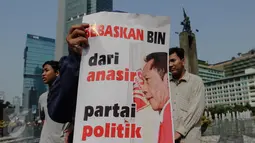 Aktivis dari Pemuda Untuk Keadilan dan Persatuan Indonesia (PKPI) poster yang berisikan penolakan pencalonan Sutiyoso jadi kepala BIN saat menggelar aksi damai di Bundaran HI, Jakarta, Minggu (28/6/2015). (Liputan6.com/Faizal Fanani)