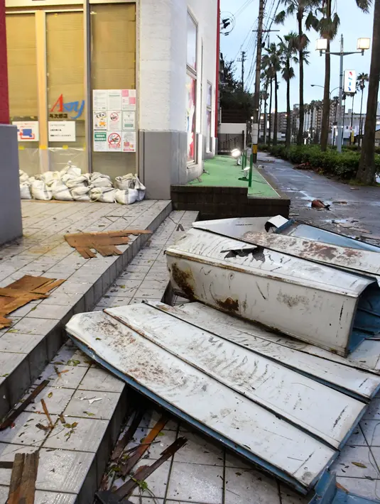 Puing-puing berserakan di trotoar setelah topan melanda Kagoshima, barat daya Jepang, Senin (7/9/2020). Badai melanda wilayah itu dengan angin kencang dan membasahi kawasan dengan hujan lebat, memutus aliran listrik ke puluhan ribu rumah di pulau-pulau selatan Jepang. (Kyodo News via AP)