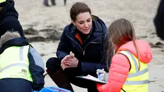 Kate Middleton, Duchess of Cambridge, berbincang dengan seorang anak sekolah saat membersihkan sampah di pantai Newborough di Wales (8/5). Pangeran William dan Kate Middleton melakukan kunjungan ke pantai Newborough untuk membersihkan sampah bersama anak-anak sekolah. (Reuters/Phil Noble)