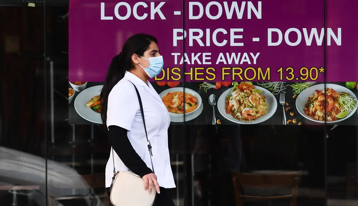 Seorang wanita yang mengenakan masker berjalan melewati sebuah restoran di Melbourne, Negara Bagian Victoria, Australia, 31 Agustus 2020. Kasus baru COVID-19 di Victoria turun setelah sebulan memberlakukan karantina wilayah (lockdown) Tahap 4 di ibu kotanya, Melbourne. (Xinhua/Bai Xue)