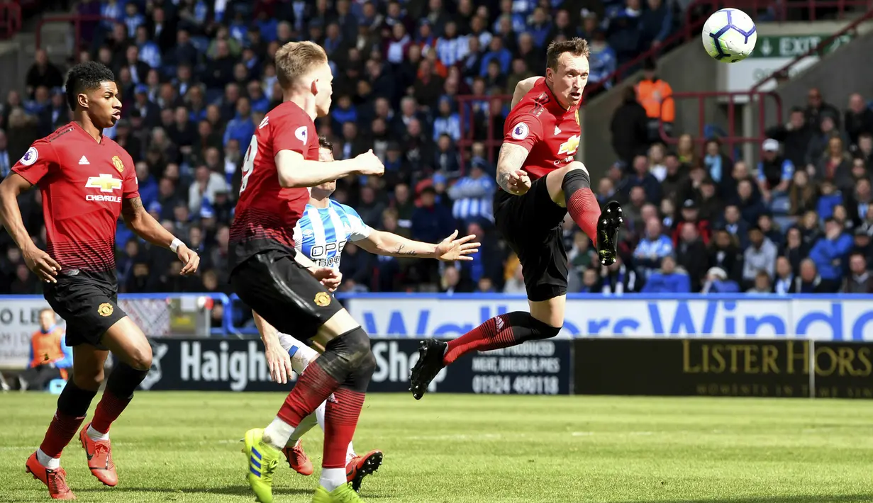 Bek Manchester United, Phil Jones, mengontrol bola saat melawan Huddersfield Town pada laga Premier League di Stadion John Smith, Minggu (5/5). Kedua tim bermain imbang 1-1. (AP/Anthony Devlin)