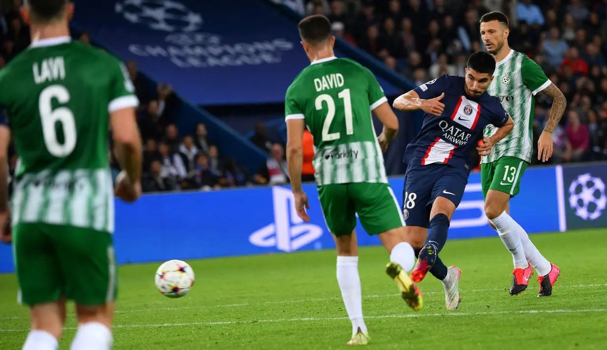 Gelandang Paris Saint-Germain (PSG) Carlos Soler menembak dan mencetak gol ke gawang Maccabi Haifa pada matchday kelima Grup H Liga Champions 2022/23 di Parc des Princes, Rabu (26/10/2022) dinihari WIB. Atas kemenangan mencolok tersebut, Les Parisiens sukses melaju ke babak 16 besar Liga Champions dengan kepala tegak. (Anne-Christine POUJOULAT / AFP)