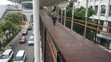 Warga melintasi jembatan penyeberangan (Skybridge) yang menghubungkan Stasiun LRT Velodrome dengan Halte Transjakarta Pemuda di Rawamangun, Jakarta, Senin (29/7/2019). Skybridge ini bertujuan memudahkan integrasi penumpang LRT menuju Transjakarta atau sebaliknya. (Liputan6.com/Immanuel Antonius)