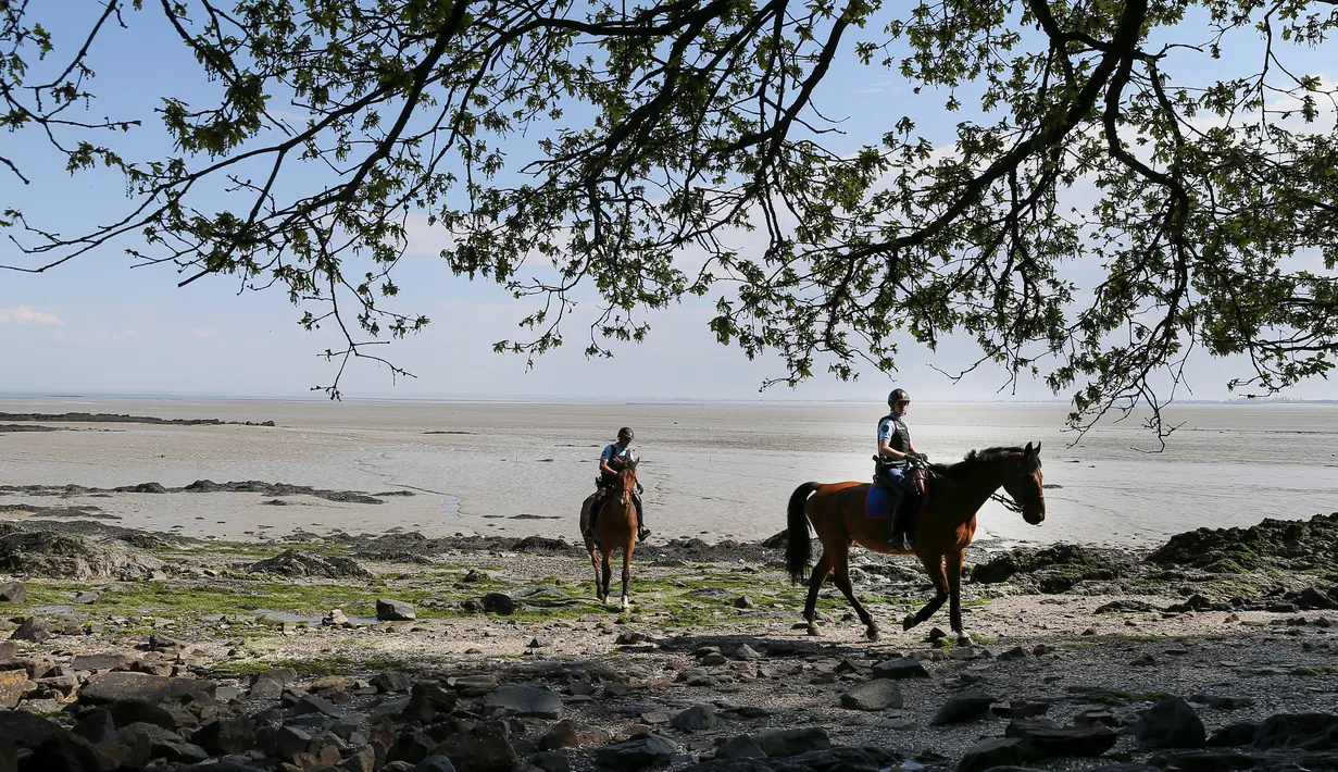 Polisi berkuda berpatroli di pantai selama lockdown nasional untuk melawan virus corona COVID-19 di Cancale, Prancis, Sabtu (11/4/2020). Prancis kini berada dalam minggu keempat lockdown akibat COVID-19. (AP Photo/David Vincent)