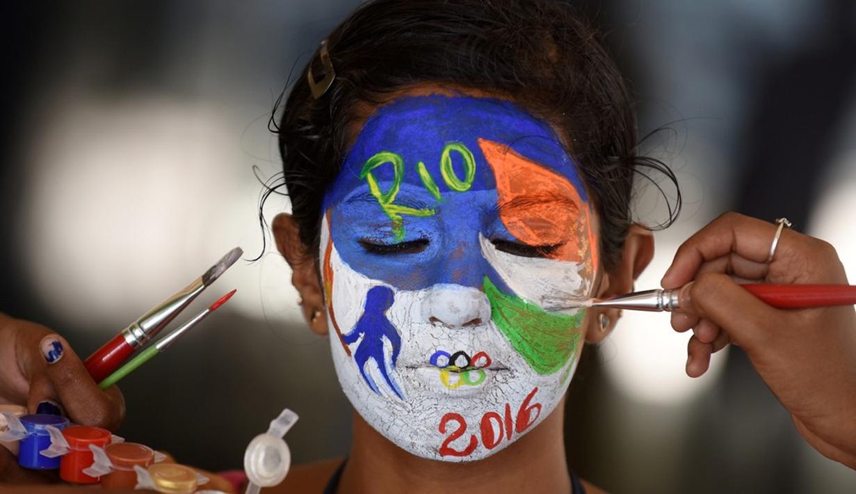 Siswa dari India mengecat wajahnya dengan logo Olimpiade Rio 2016 untuk mendukung tim India di Chennai, India, (4/8/2016). (AFP/Arun Sankar)