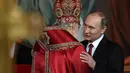  Presiden Rusia, Vladimir Putin memeluk kepala Gereja Ortodoks Rusia usai menjalani prosesi Paskah Ortodoks di Gereja Katedral Kristus Juru Selamat di Moskow, Rusia, (16/4). (AFP Photo / Vasily Maximov)