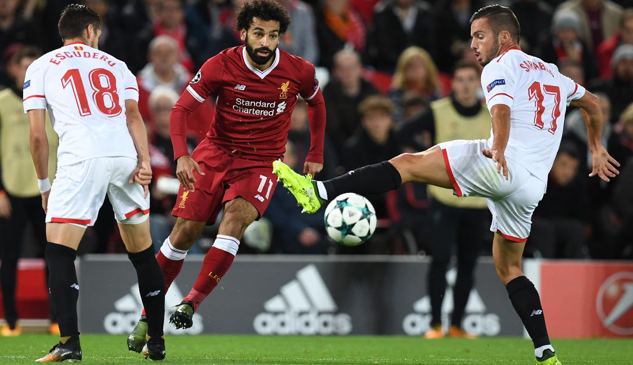 Gelandang Liverpool, Mohamed Salah berebut bola dengan pemain Sevilla, Sergio Escudero dan Pablo Sarabia dalam laga Grup E Liga Champions di Stadion Anfield, Rabu (13/9). Sevilla berhasil menahan imbang Liverpool dengan skor 2-2. (Paul ELLIS / AFP)