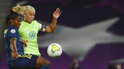 Pemain Lyon, Kadeisha Buchanan, berebut bola dengan pemain Wolfsburg, Pernille Harder, pada laga Liga Champions Wanita di Stadion Anoeta, Spanyol, Senin (31/8/2020). Lyon menang 3-1 atas Wolfsburg. (Gabriel Buoys/Pool via AP)