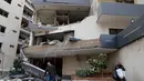Israel menyebut serangan tersebut menargetkan fasilitas komunikasi satelit dan gudang senjata milik intelijen Hizbullah. Tampak dalam foto, para tamu hotel membawa barang-barang mereka saat meninggalkan hotel yang rusak akibat serangan udara Israel di Hazmieh, sebelah timur Beirut, Lebanon, Rabu 4 Maret 2026. (AP Photo/Hussein Malla)