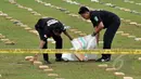 Petugas kepolisian memasukan barang bukti ganja kedalam karung saat rilis pengungkapan di Lapangan Bhayangkara, Jakarta, Senin (11/5/2015). 2,1 ton ganja kering asal Aceh diamankan Ditnarkoba Mabes Polri. (Liputan6.com/JohanTallo)