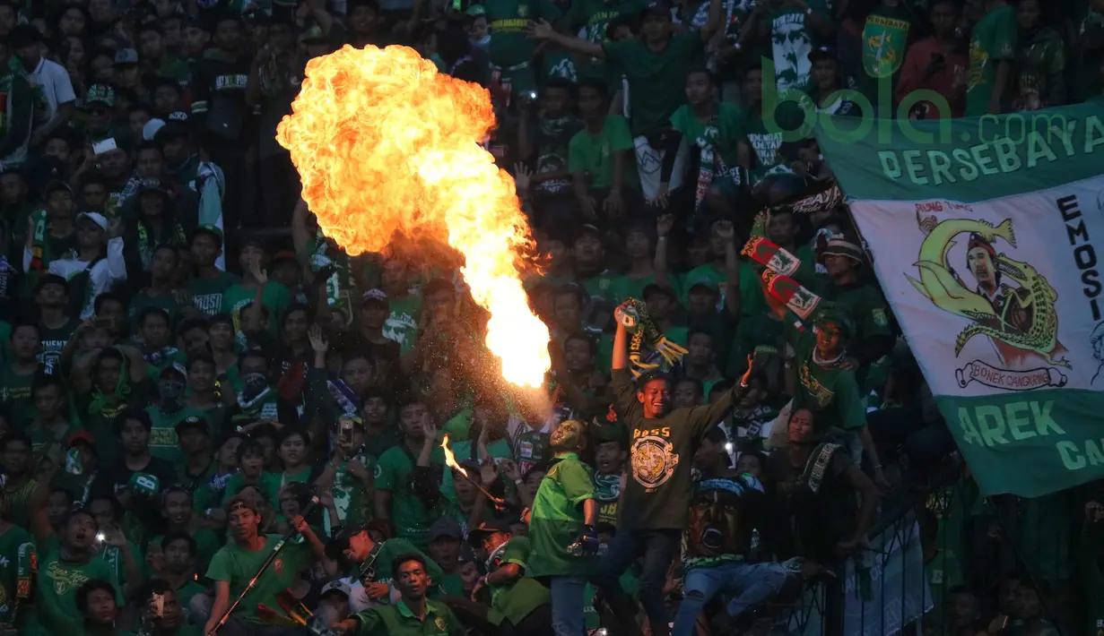 Aksi Debus ala Bonek dengan menyeburkan api saat Persebaya Surabaya melawan Arema FC pada lanjutan Liga 1 Indonesia 2018 di Stadion Gelora Bung Tomo, Surabaya (6/5/2018). Persebaya Surabaya menang tipis 1-0. (Bola.com/Aditya Wany)