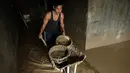Upaya pembersihan dilakukan di tengah keterbatasan pasokan air bersih. Tampak dalam foto, Panji (23 tahun) membawa lumpur keluar dari dapur menggunakan gerobak dorong di rumah orang tuanya di Aceh Tamiang, Minggu 14 Desember 2025. (Yasuyoshi CHIBA/AFP)