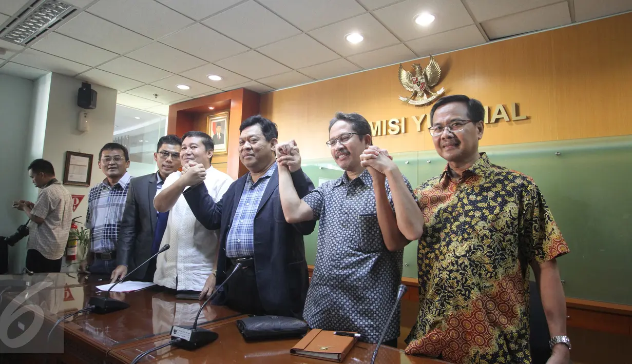 Komisioner KY Taufiqurahman Sahuri dan Imam Anshori Saleh berjabat tangan usai memberikan keterangan terkait penetapan tersangka ketua dan komisioner KY dalam dugaan pencemaran nama baik Hakim Sarpin, Jakarta, Minggu (12/7). (Liputan6.com/Faizal Fanani)  