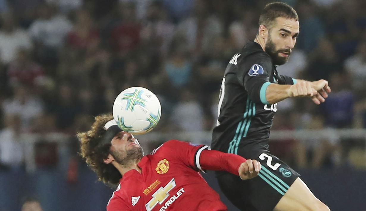 Gelandang Manchester United, Marouane Fellaini, duel udara dengan bek Real Madrid, Daniel Carvajal, pada laga Piala Super Eropa di Stadion Philip II, Skopje, Selasa (8/8/2017). Foto muka unik Fellaini viral di media sosial. (AP/Boris Grdanoski)