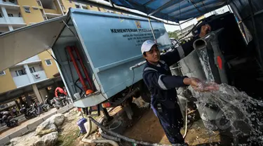 Petugas menunjukkan air bersih dari hasil sulingan di Rusun Muara Baru, Jakarta, Rabu (22/4/2015). Minimnya air bersih di rusun tersebut membuat kementerian pekerja umum menyediakan alat penyulingan air . (Liputan6.com/Faizal Fanani)