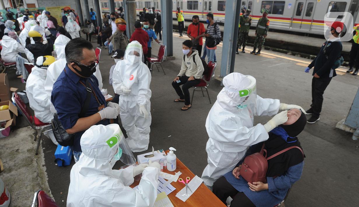 Paramedis mengambil sampel penumpang KRL Commuter Line saat tes swab di Stasiun Bojonggeder, Jawa Barat, Senin (11/05/2020).  Tes swab dan rapid dilakaukan sebagai salah satu metode untuk mendeteksi dan mencegah penyebaran Covid-19 di moda transportasi KRL Commuter Line. (merdeka.com/Arie Basuki)