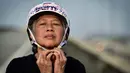 Longboarder dan penderita kanker Nongluck Chairuettichai, juga dikenal sebagai Jeab, mengenakan helm sebelum latihan di Bangkok, 9 September 2020. Melaju di jalan raya Bangkok yang kosong, kegiatan ini dilakukan sebagai jalan pemulihan dari kanker payudara yang dideritanya. (Lillian SUWANRUMPHA/AFP)