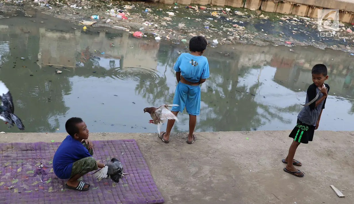 Anak-anak bermain di bantaran anak Sungai Ciliwung, Jakarta, Rabu (6/6). Meskipun tidak layak sebagai tempat bermain, namun lokasi itu menjadi tempat bagi anak-anak di kawasan tersebut untuk menunggu waktu berbuka. (Liputan6.com/Immanuel Antonius)