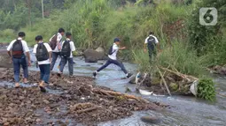 Tidak adanya jembatan penghubung di kampung tersebut, memaksa para pelajar dari berbagai tingkat sekolah menyeberangi Sungai Cihideung untuk menuju sekolah mereka masing-masing. (Liputan6.com/Herman Zakharia)