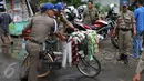 Petugas Satpol PP membawa barang dagangan milik pedagang kopi keliling saat melakukan razia di kawasan SCBD, Jakarta, Senin (21/11). Satpol PP merazia dan menyita dagangan yang beroperasi di kawasan tersebut. (Liputan6.com/Gempur M Surya)