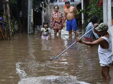 Warga membersihkan banjir yang menggenangi kawasan Cilandak Timur, Jakarta Selatan, Selasa (22/1). Hujan deras yang mengguyur Jakarta dan sekitarnya sejak pagi menyebabkan banjir di sejumlah sudut Ibu Kota. (Liputan6.com/Immanuel Antonius)