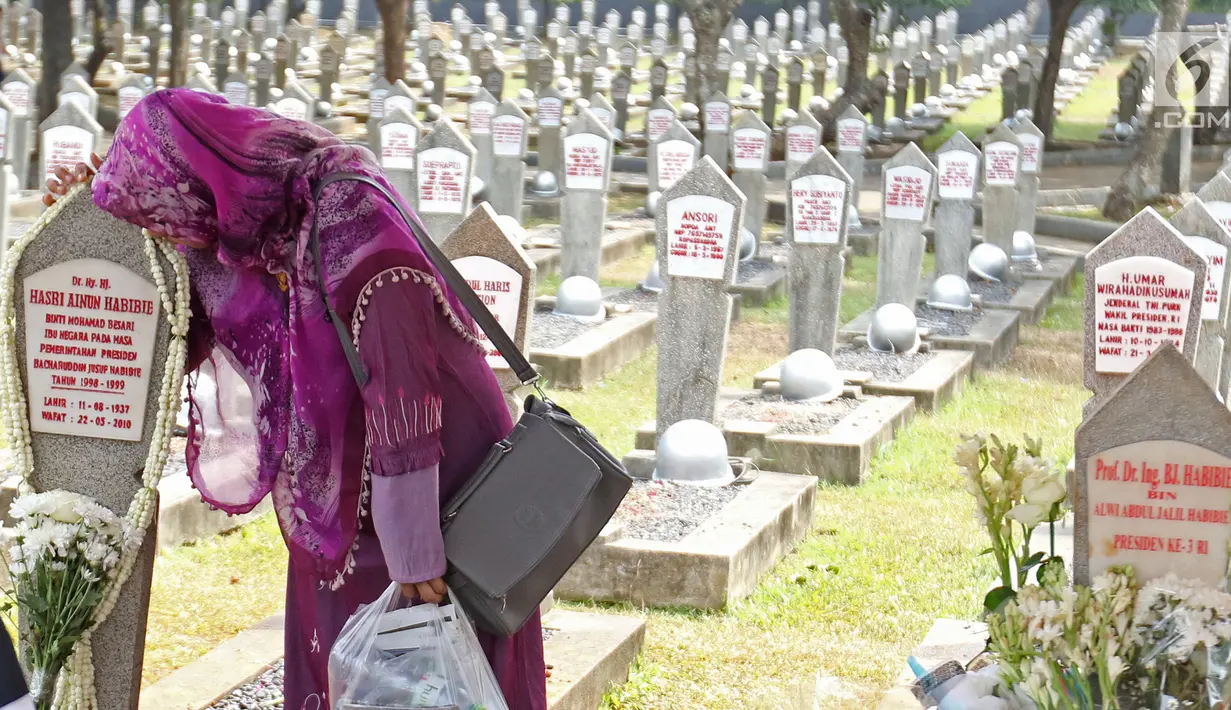 Warga mencium batu nisan di makam Hasri Ainun Besari yang bersebelah dengan makam sang suami, Presiden ke-3 RI BJ Habibie di TMP Kalibata, Jakarta, Jumat (13/9/2019). Sesuai permintaannya semasa hidup, BJ Habibie dimakamkan bersebelahan dengan mendiang istrinya Ainun. (Liputan6.com/Herman Zakharia)
