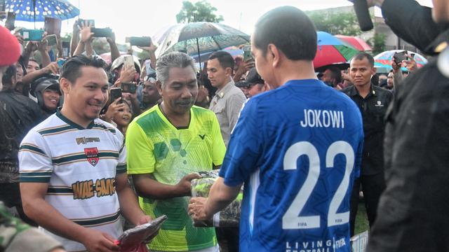 Presiden Joko Widodo atau Jokowi bermain sepak bola bersama warga Desa Batu Cermin di Lapangan Bola Wae Kesambi, NTT, Senin (4/12/2023).