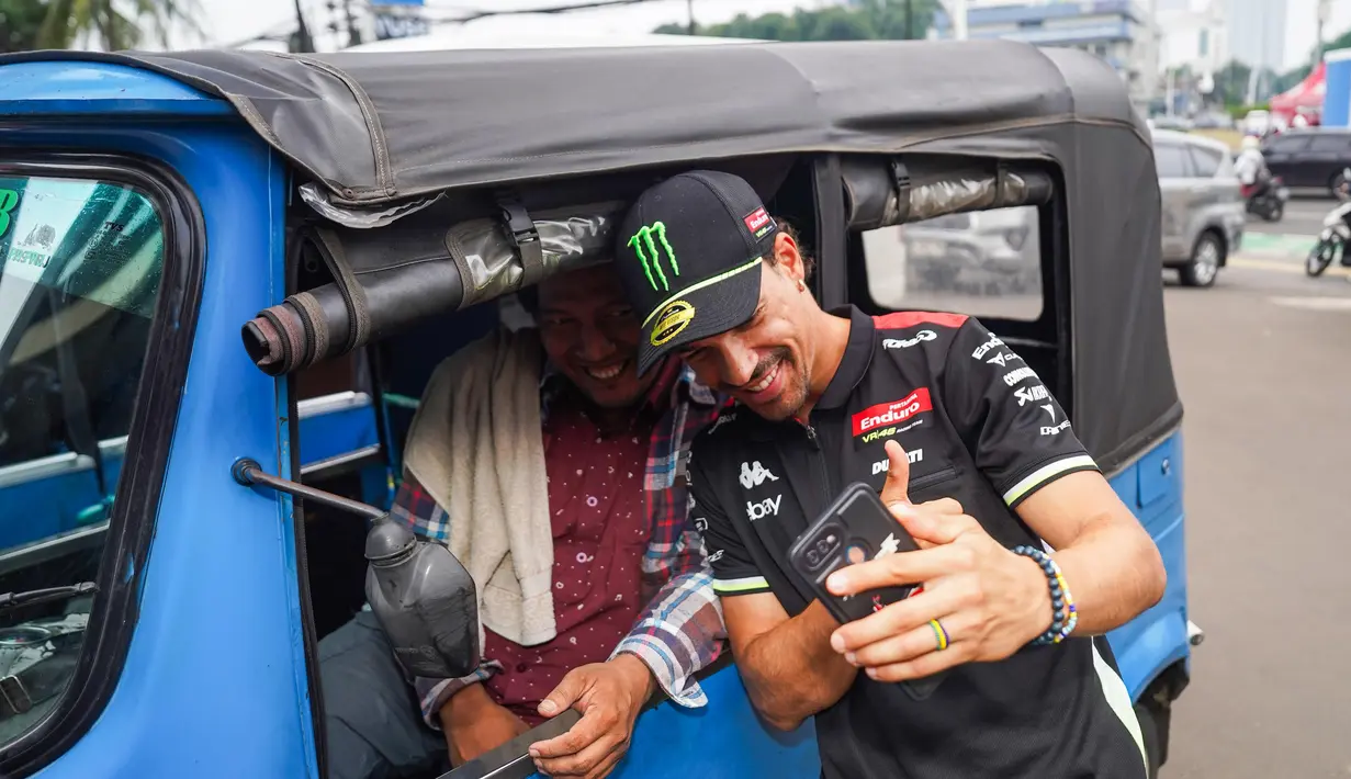 Momen keakraban Franco Morbidelli dengan pengemudi Bajaj sebelum menjajal perjalanan menggunakan bajaj pada Selasa, (30/09/2025). (Dok.Pertamina Lubricants)
