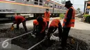 Pekerja menyelesaikan proses penggantian bantalan rel kereta api di kawasan Stasiun Karet, Jakarta, Rabu (28/12). Perawatan tersebut dilakukan untuk memperbaiki keseimbangan tinggi dan rendah rel kereta. (Liputan6.com/Gempur M. Surya)