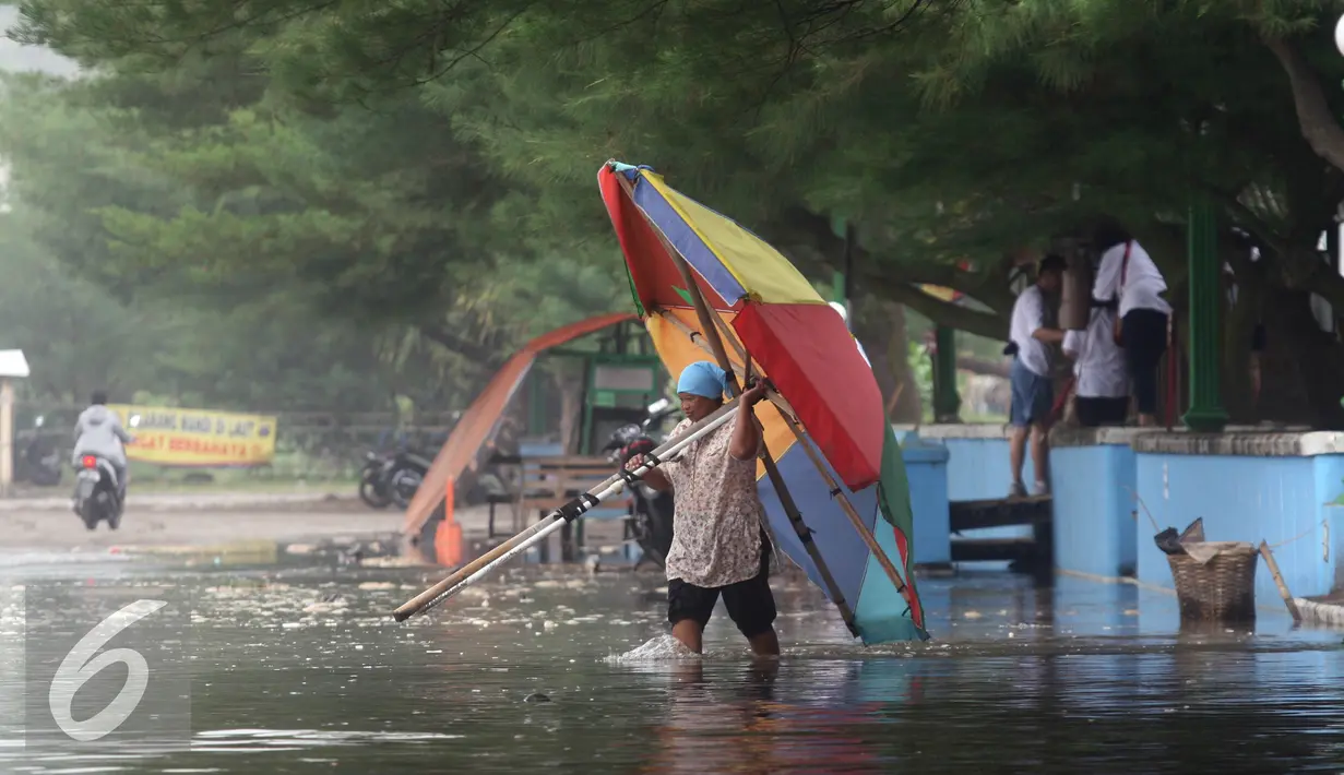 Warga mengevakuasi perabot warungnya dari terjangan gelombang pasang di Pantai Depok,Yogyakarta, Kamis (9/6). Kondisi yang terjadi di pesisir laut selatan tersebut di perkirakan akan terjadi hingga seminggu ke depan.(Liputan6.com/Boy Harjanto)