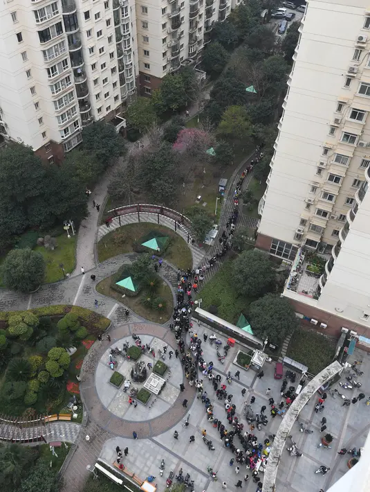 Foto udara menunjukkan warga mengantre untuk menjalani tes asam nukleat untuk virus corona Covid-19 di Wuhan di provinsi Hubei, China tengah,  Selasa (22/2/2022). Wuhan, wabah besar pertama dari pandemi virus corona melaporkan lebih dari selusin kasus virus corona baru minggu ini. (AFP/China Out)