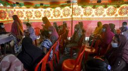 Para pekerja seks komersial (PSK) menunggu saat mengikuti vaksinasi COVID-19 di Daulatdia, Bangladesh, 18 Agustus 2021. Bangladesh terus menggencarkan vaksinasi COVID-19, kegiatan ini turut menyasar para PSK di pusat prostitusi. (Munir Uz zaman/AFP)
