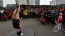 Para pengunjung Car Free Day menikmati suguhan yang ditampilkan pegiat 'Pole Dance'  di Bundaran HI, Jakarta, Minggu (18/1/2015). (Liputan6.com/Miftahul Hayat)