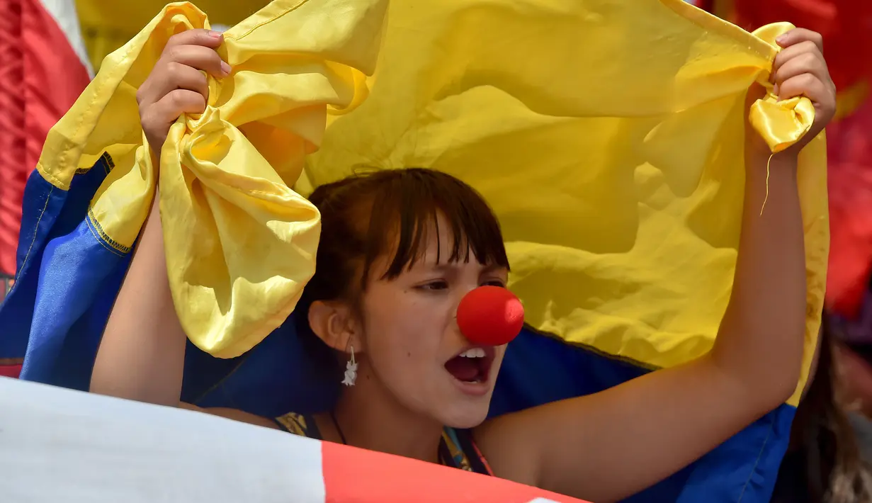 Seorang wanita berteriak saat menggelar aksi mogok nasional di Bogota, Kolombia, (17/3). Unjuk rasa tersebut juga menuntut pemerintah agar meningkatkan upah buruh. (AFP/Guillermo LEGARIA)