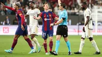 Wasit Juan Martinez Munuera memberikan kartu merah kepada bek Barcelona Ronald Araujo&nbsp;dalam pertandingan final Piala Super Spanyol di Stadion Al Awwal, Riyadh, Arab Saudi, Senin, 15 Januari 2024. (Giuseppe CACACE / AFP)