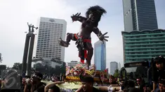 Sejumlah orang mengarak ogoh-ogoh saat Car Free Day di Bundaran HI, Jakarta, Minggu (19/3). Kegiatan tersebut untuk menyosialisasikan pawai ogoh-ogoh di Pura Agung Wira Satya Bhuana, Jakarta, pada Senin (27/3). (Liputan6.com/Angga Yuniar)