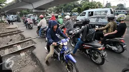 Sejumlah kendaraan melintasi perlintasan sebidang di Stasiun Duren Kalibata, Jakarta, Kamis (14/7). Sudin Perhubungan dan Transportasi berencana akan menutup permanen perlintasan sebidang di Stasiun KA Duren Kalibata. (Liputan6.com/Yoppy Renato)