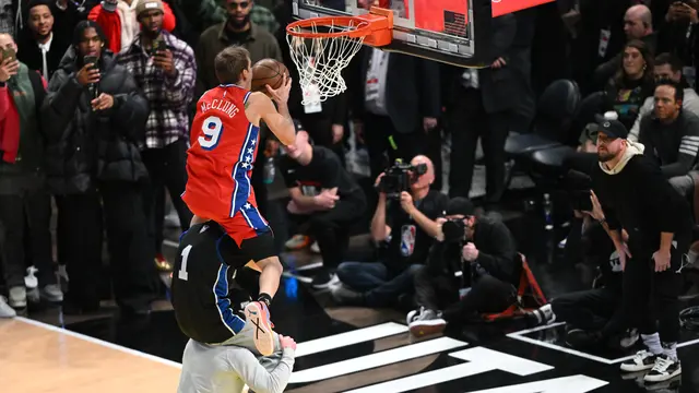 Mac McClung melompati dua orang yang bergendongan di kontes slam dunk NBA All-Star 2023