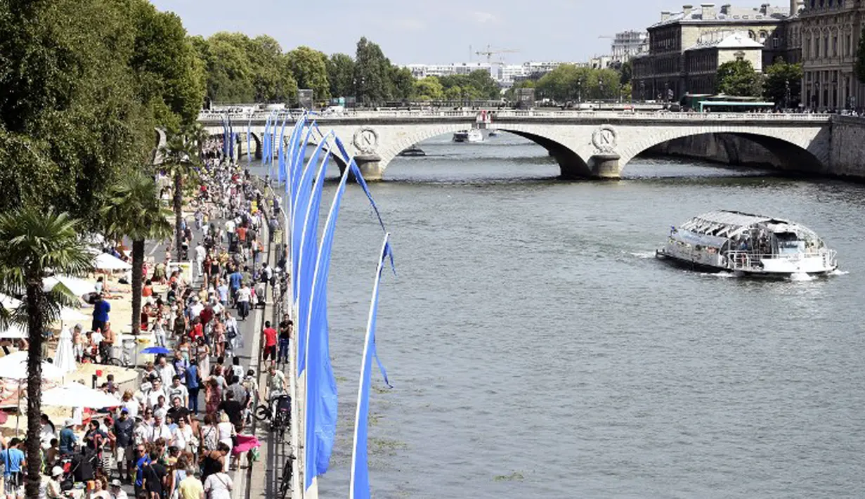 Bantaran Sungai Seine disulap menjadi pantai buatan lengkap dengan pasir dan bangku santai, Perancis, Rabu (22/7/2015).  Tahun ini adalah edisi ke-14 dari Paris Plages, acara budaya dan wisata utama di Paris selama musim panas. (AFP Photo/Miguel Medina)