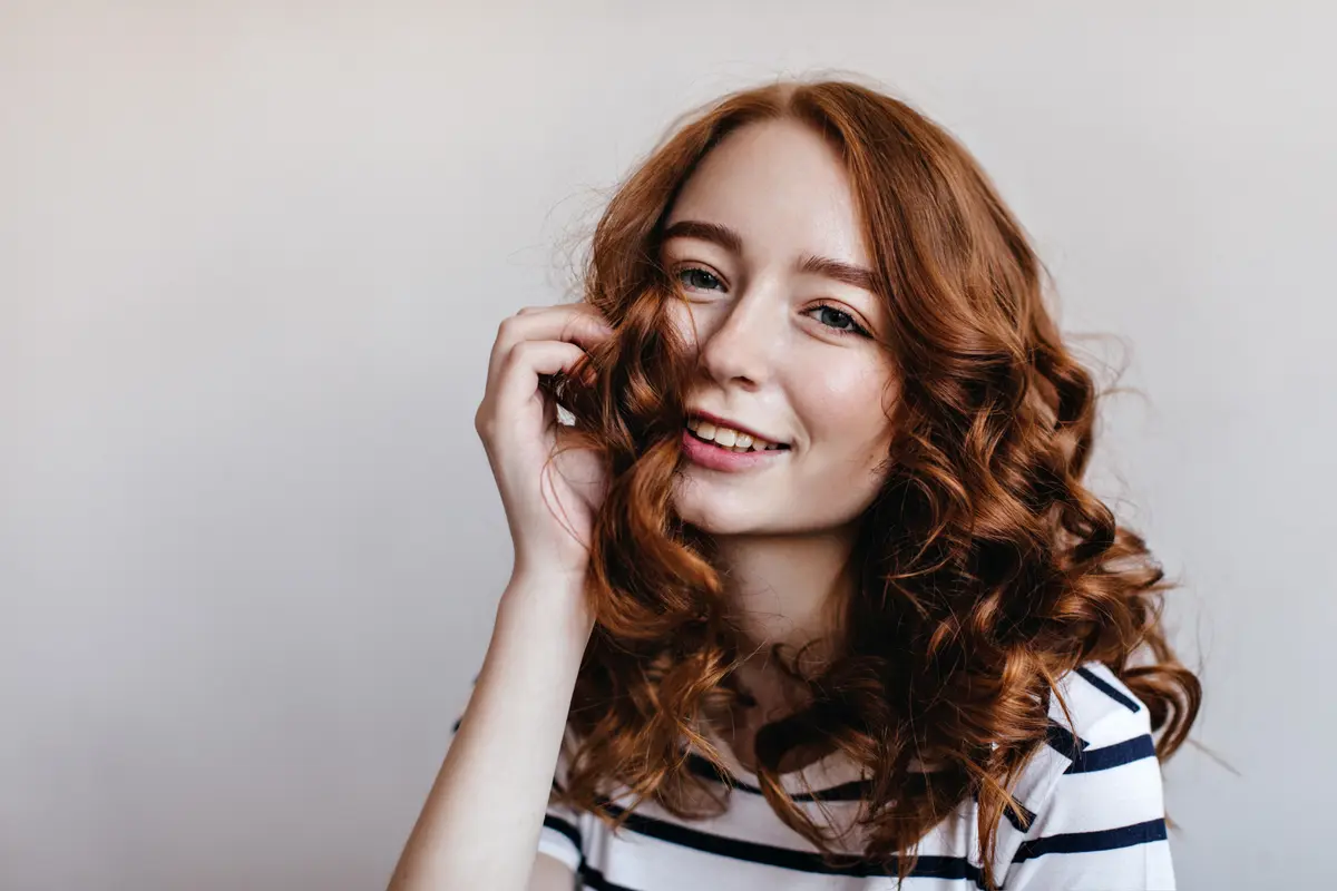 Seorang perempuan dengan rambut keriting bergelombang (Foto Dok: Freepik/lookstudio)