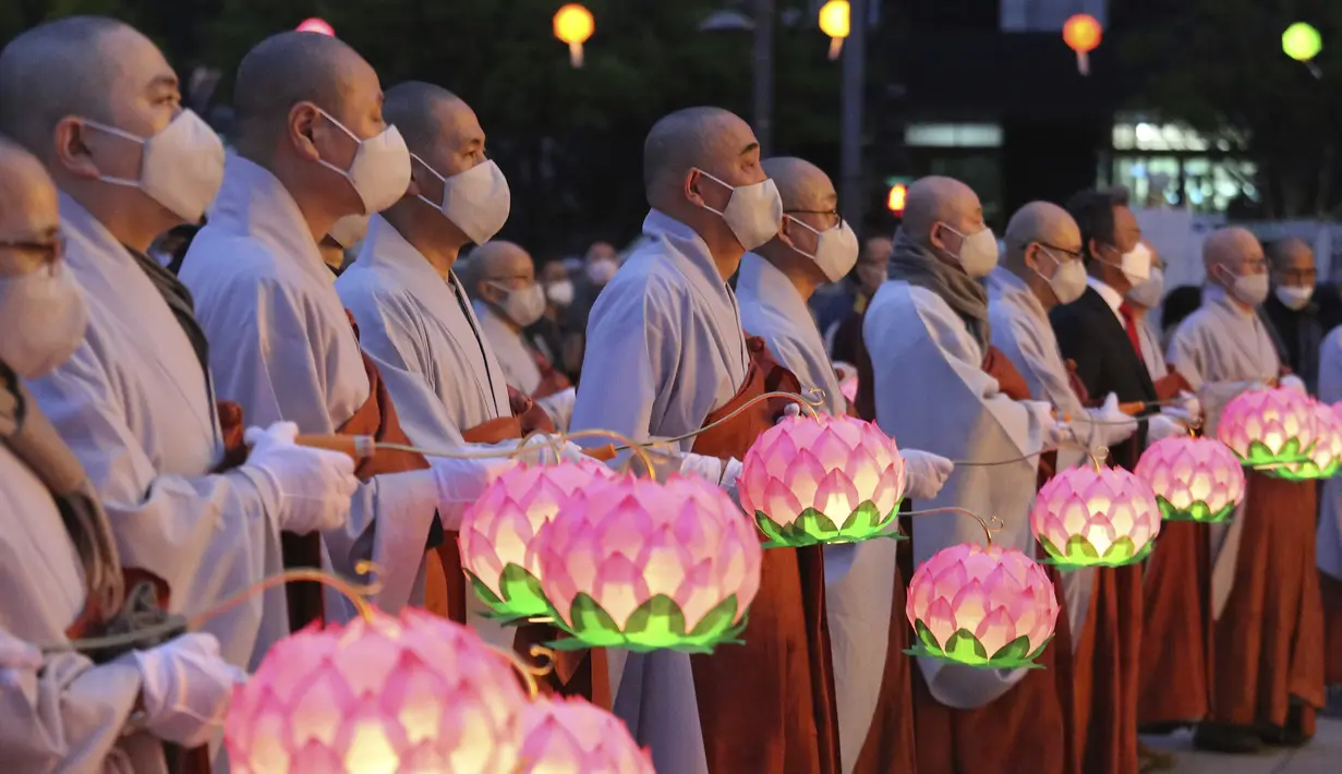 Para biksu mengenakan masker saat merayakan ulang tahun Buddha di Gwanghwamun Plaza, Seoul, Korea Selatan, Kamis (30/4/2020). Ulang tahun Buddha kali ini dirayakan di tengah pandemi virus corona COVID-19. (AP Photo/Ahn Young-joon)