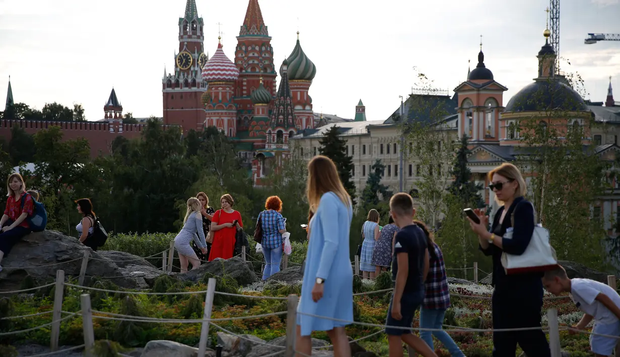 Sejumlah orang berjalan-jalan di Zaryadye Park jelang final Piala Dunia 2018 antara Prancis melawan Kroasia di Moskow, Rusia, (13/7).  (AP Photo/Rebecca Blackwell)