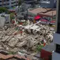 Petugas penyelamat menggali tumpukan puing-puing setelah sebuah bangunan runtuh di Fortaleza, negara bagian Ceara, Brasil, Selasa (15/10/2019). Pejalan kaki yang tengah melewati gedung ketika runtuh juga dibawa ke klinik medis terdekat. (RODRIGO PATROCINIO / AFP)