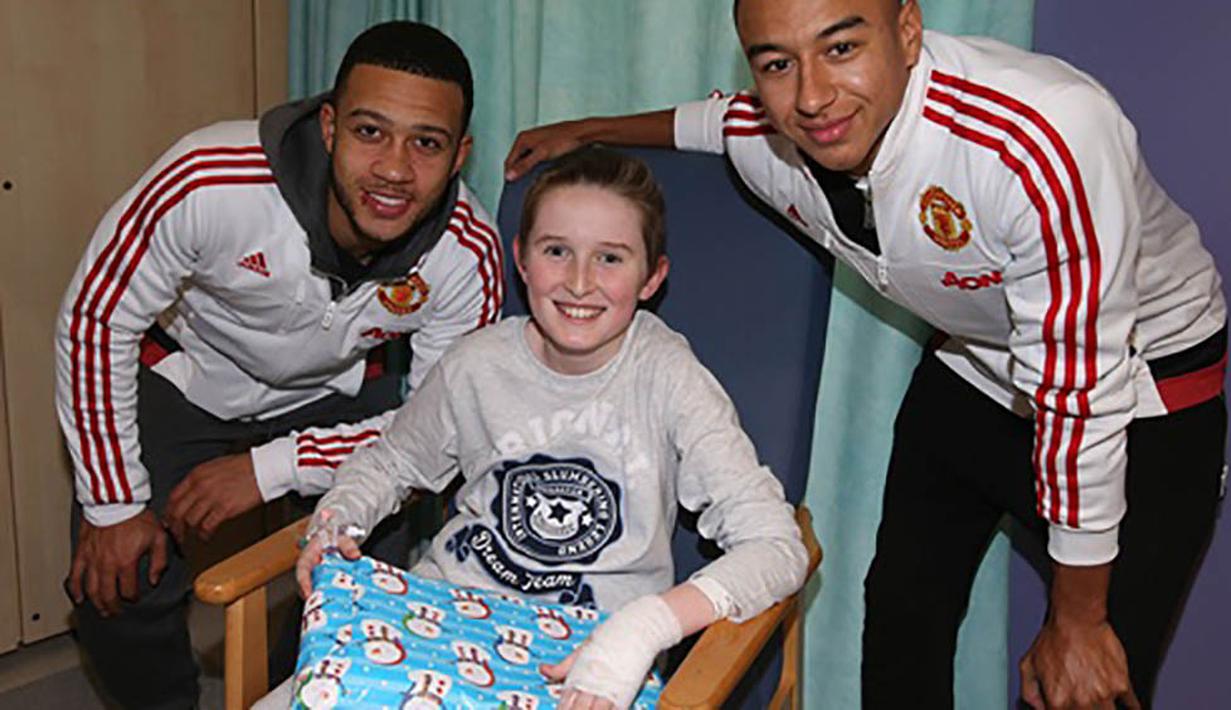 Pesepak bola Manchester United, Memphis Depay dan Jesse Lingard foto bersama seorang anak yang sedang dirawat di Rumah Sakit Royal Manchester Children. (www.manutd.com)