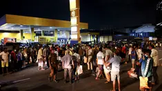 Warga berkumpul di pompa bensin untuk membeli minyak tanah di Kolombo (22/3/2022). Sri Lanka memerintahkan pasukan ke pompa bensin pada 22 Maret ketika protes sporadis meletus di antara ribuan pengendara yang mengantre setiap hari untuk mendapatkan bahan bakar yang langka. (AFP/Ishara S.Kodikara)