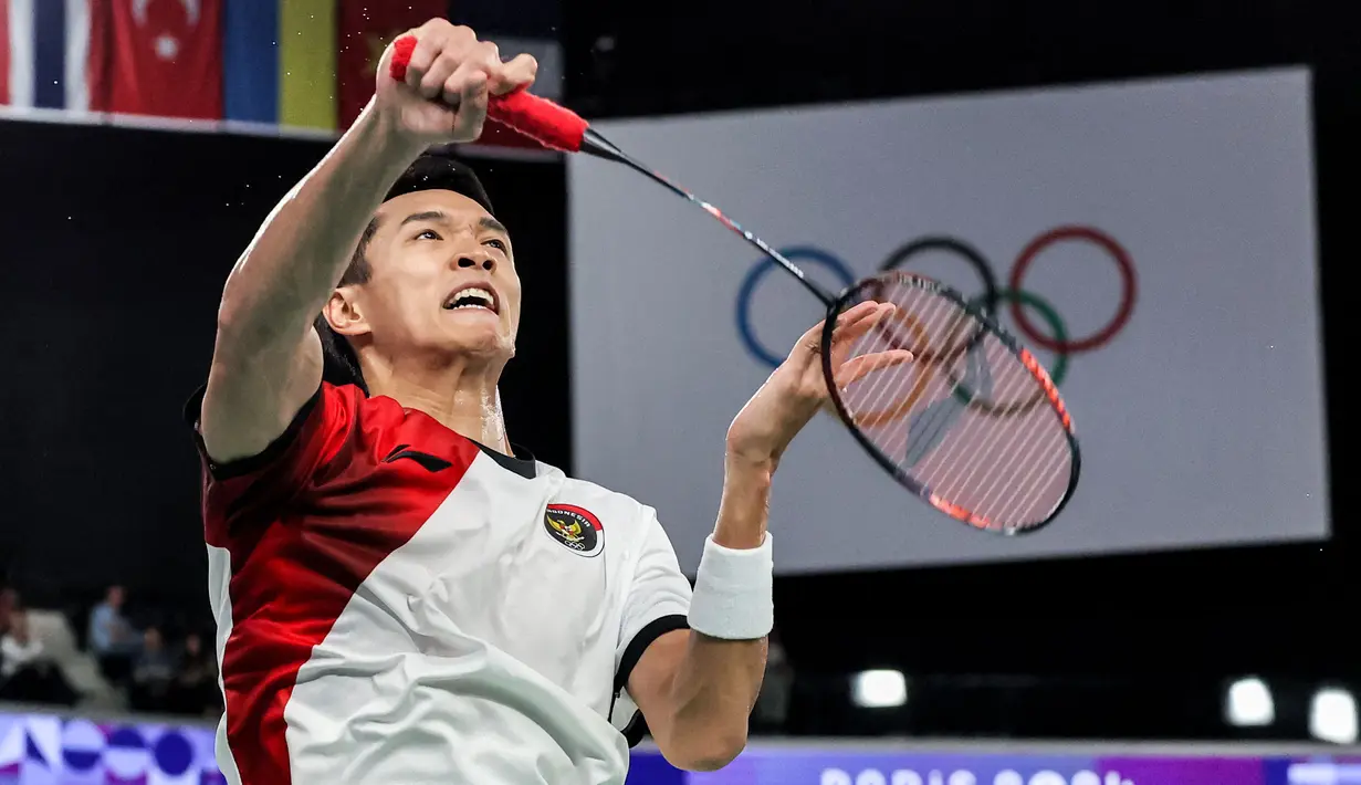 Pebulu tangkis tunggal putra Indonesia, Jonatan Christie berusaha mengembalikan kok ke arah wakil Belgia, Julien Carraggi pada laga Grup L cabang olahraga bulu tangkis Olimpiade Paris 2024 di Porte de la Chapelle Arena, Paris, Prancis, Sabtu (27/07/2024). (AFP/David Gray)