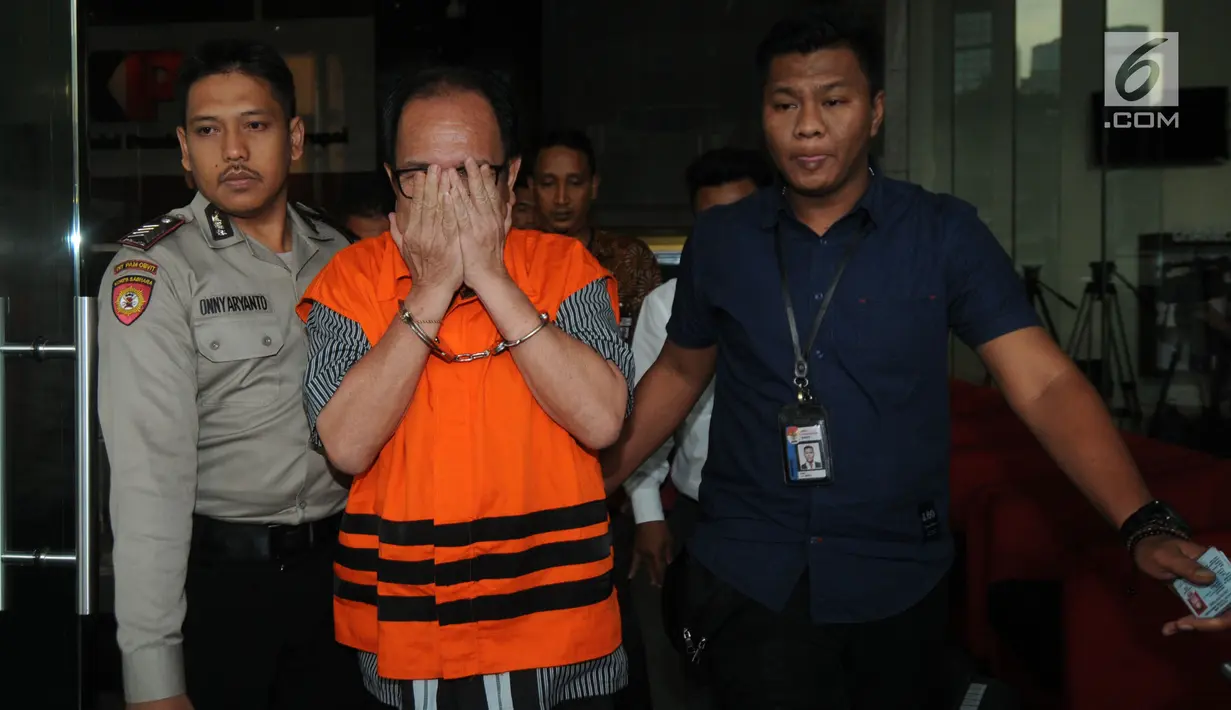 Pihak swasta Joe Fandy Yoesman alias Asiang menutupi wajahnya usai menjalani pemeriksaan di Gedung KPK, Jakarta, Kamis (18/7). Asiang resmi ditahan untuk mempermudah pemeriksaan terkait terkait kasus dugaan suap pengesahan APBD 2017-2018 Provinsi Jambi. (merdeka.com/Dwi Narwoko)